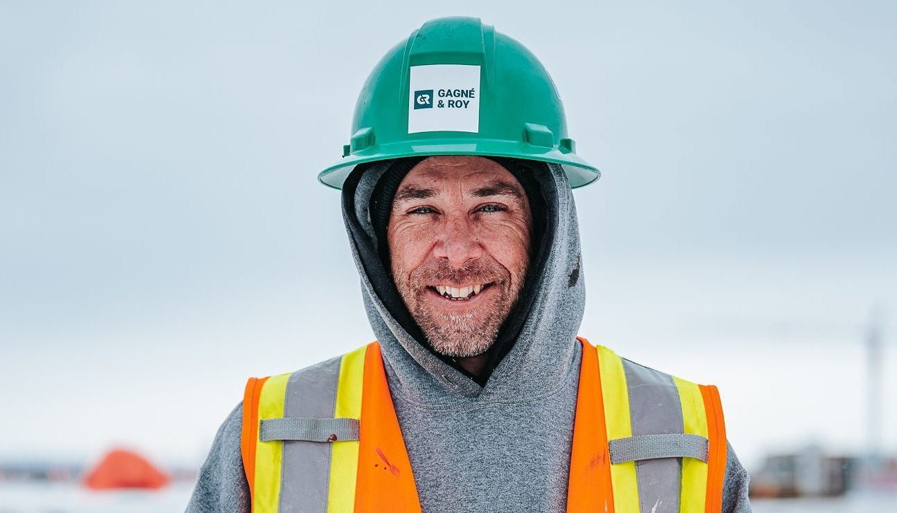 Employé Gagné et Roy souriant sur un chantier l'hiver