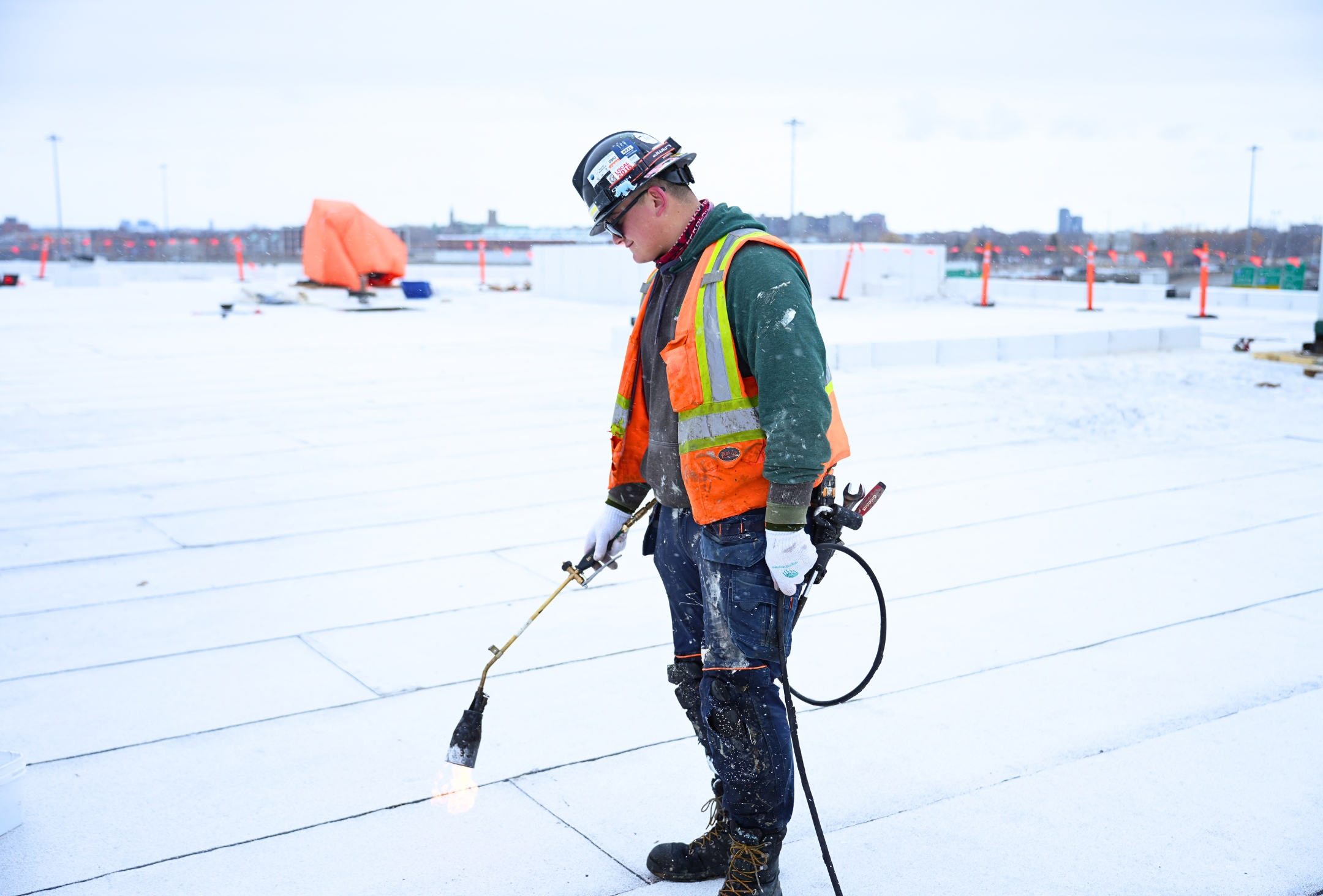 homme avec une torche travaillant sur un chantier en hiver